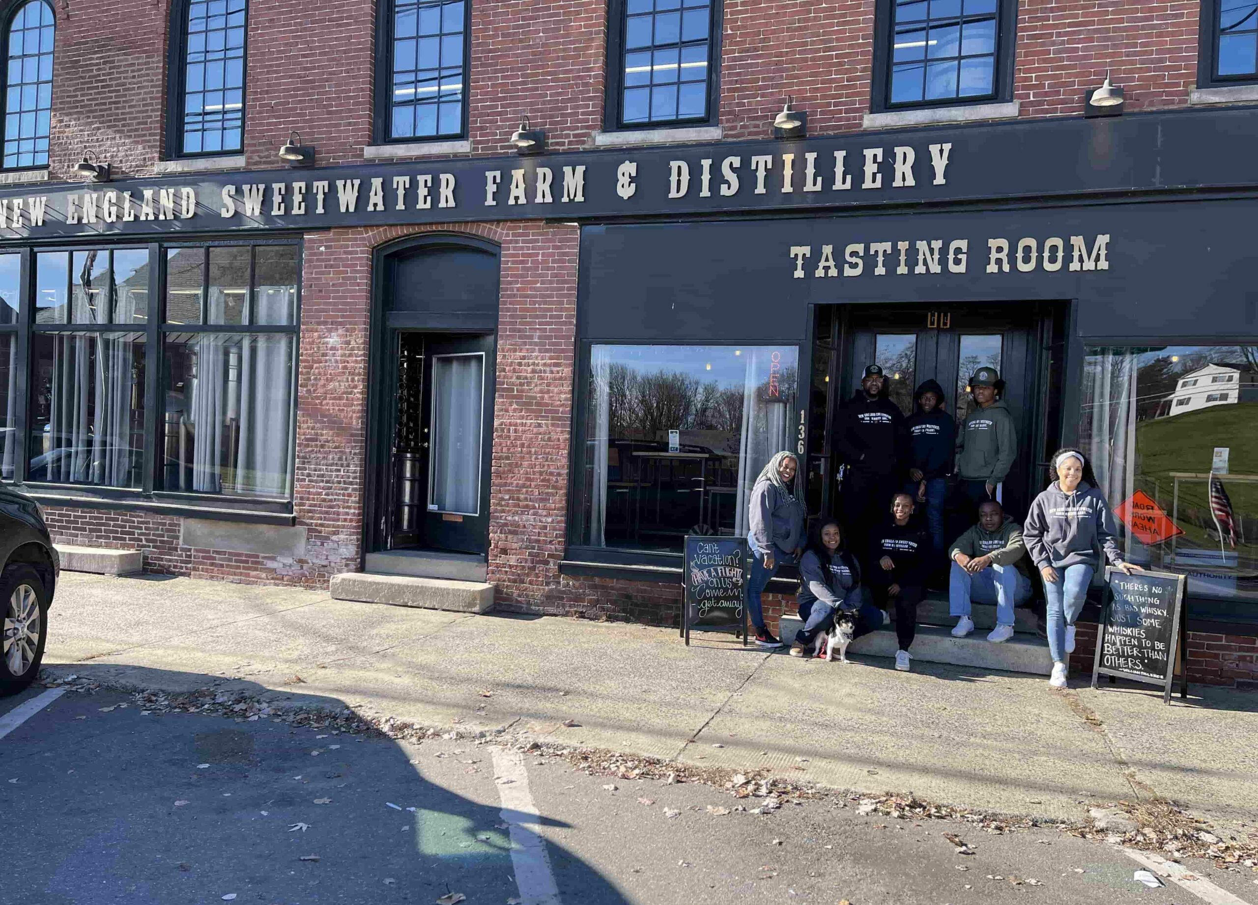 New England Sweetwater Farm and Distillery family photo in front of the tasting room at the new england distillery